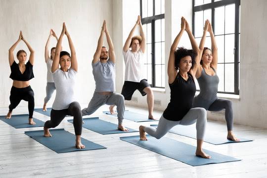 Group of people practicing yoga together in class
