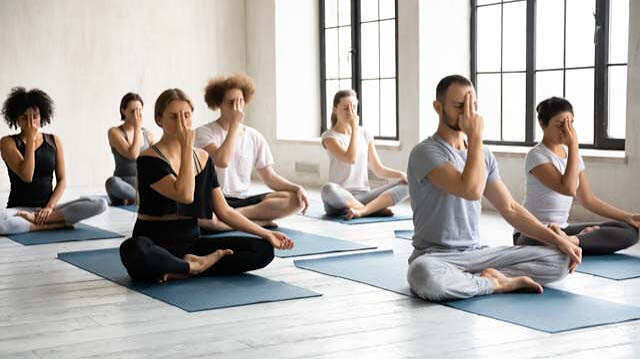 Person sitting calmly and practicing pranayama breathing with a mudra